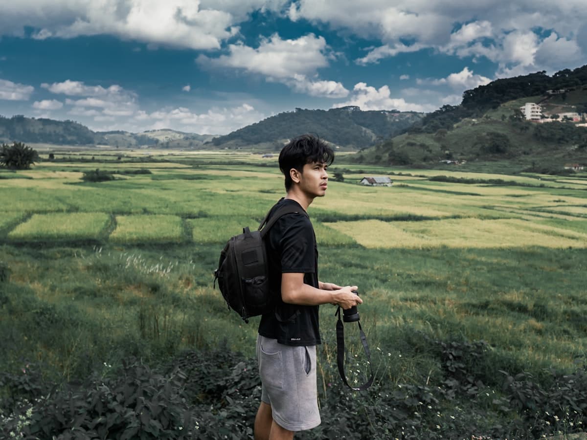A walker crossing an open grassy ridge in the West Jaintia Hills of Meghalaya.