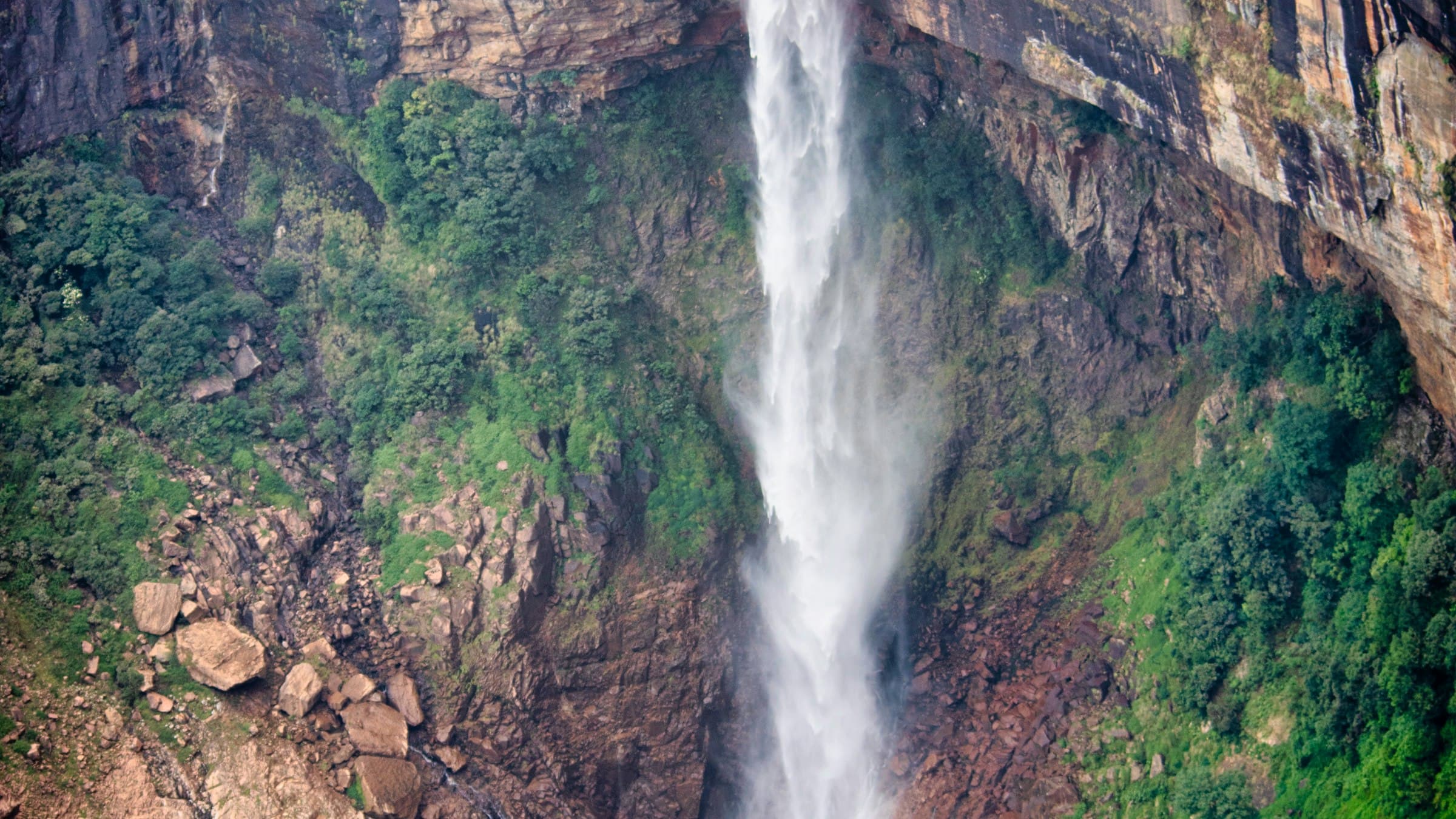 Nohkalikai Falls plunging in a single column into the blue-green pool at its base.