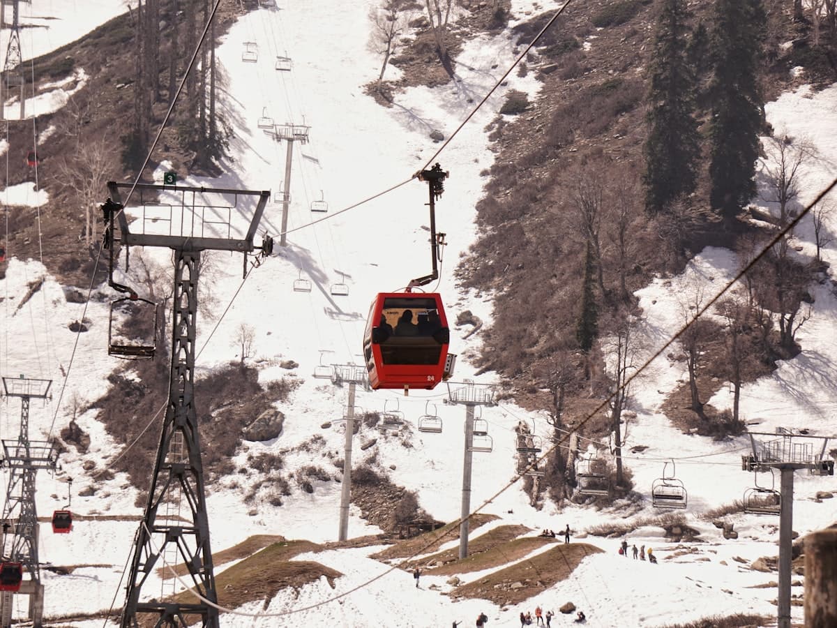 A gondola cable car climbs a snow-covered slope at Gulmarg.