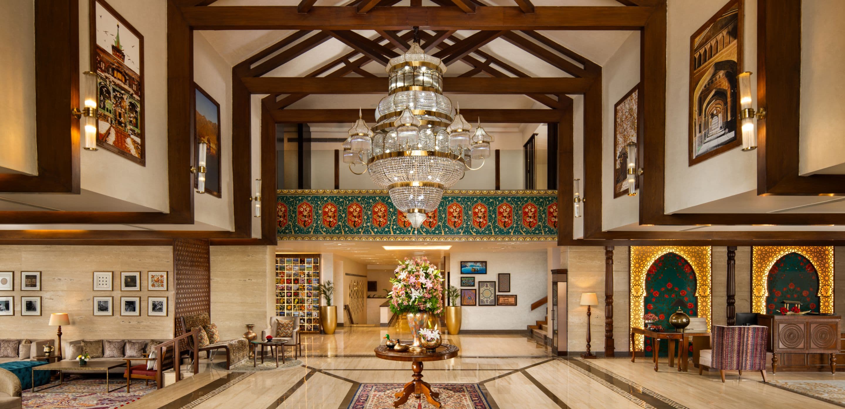The lobby lounge of Taj Dal View, Srinagar with a grand chandelier and Kashmiri decorative panels.