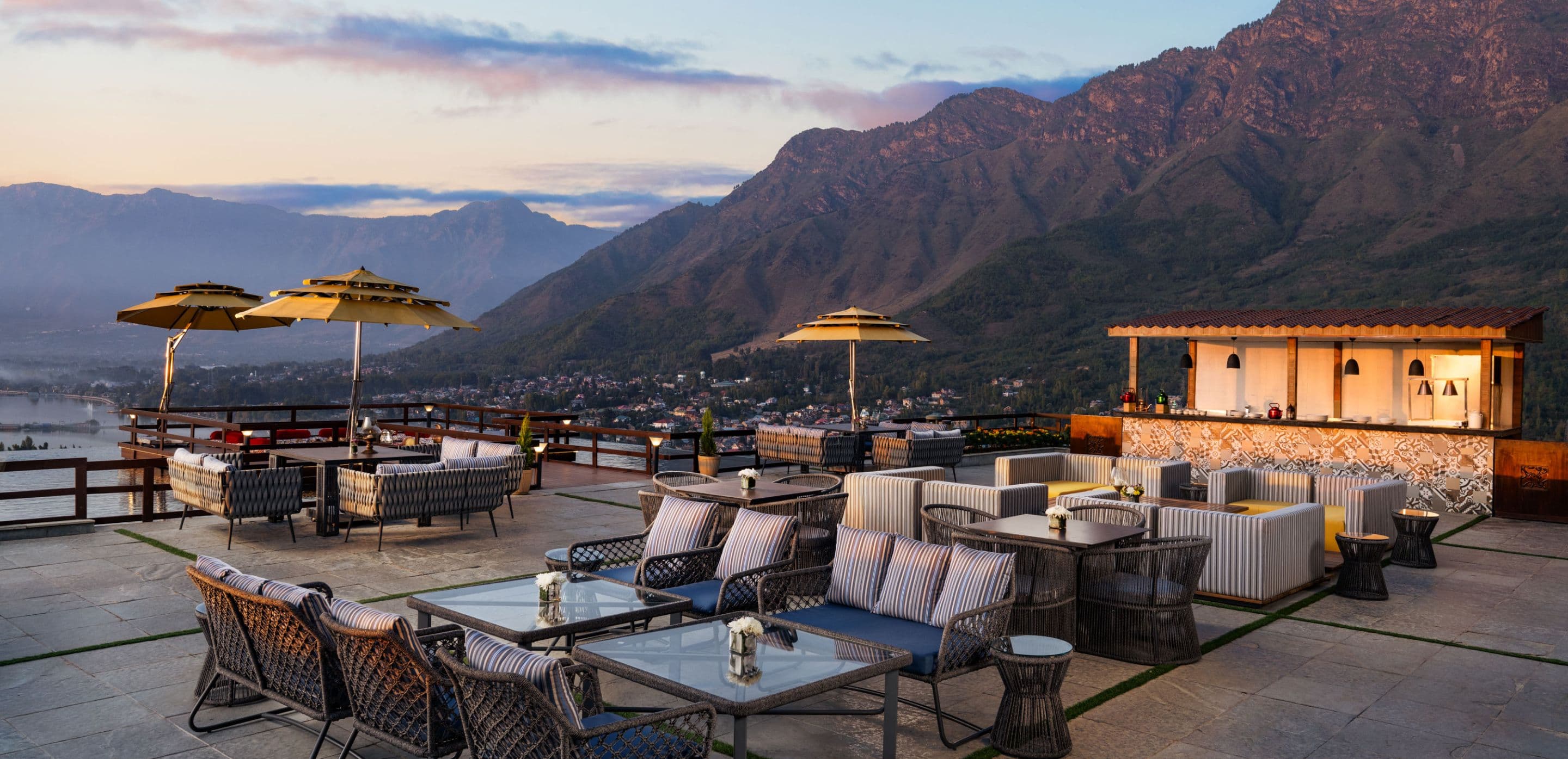 The open-air rooftop terrace lounge at Taj Dal View, Srinagar overlooking Dal Lake and the mountains.