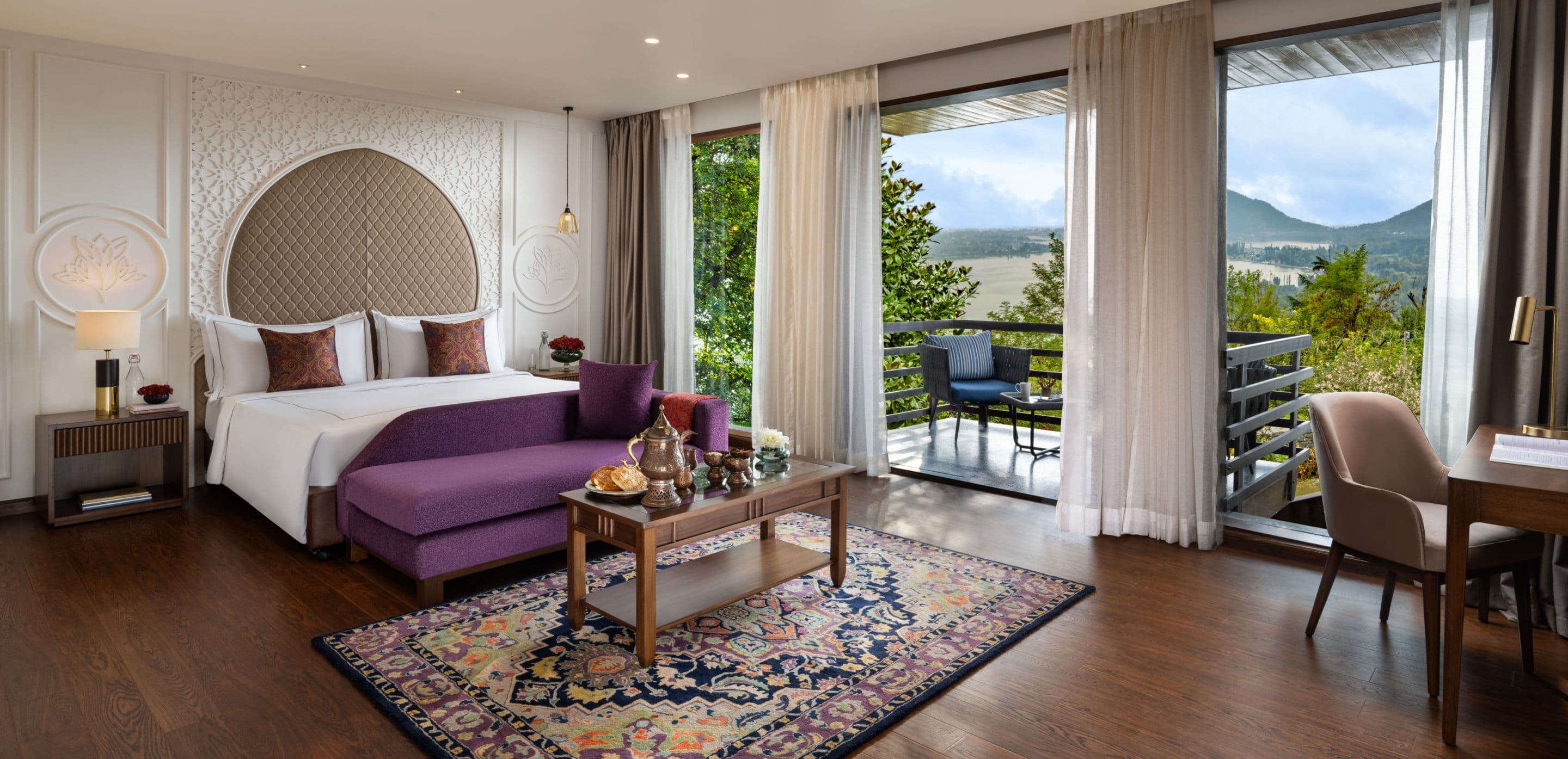 A suite at Taj Dal View, Srinagar with a chaise lounge and a private balcony framing the valley view.