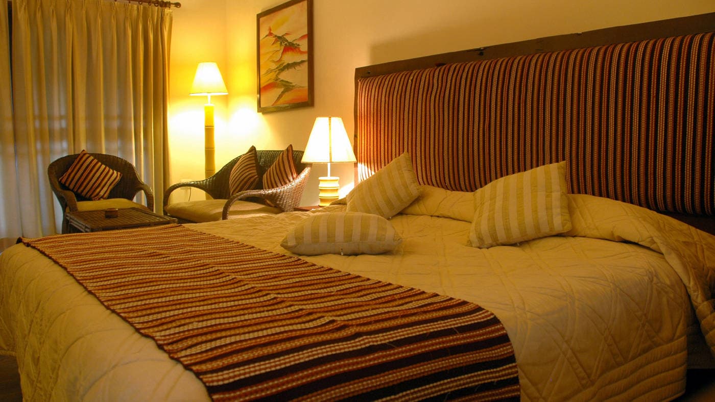 A second guest room with a king bed and warm lighting at IORA - The Retreat.