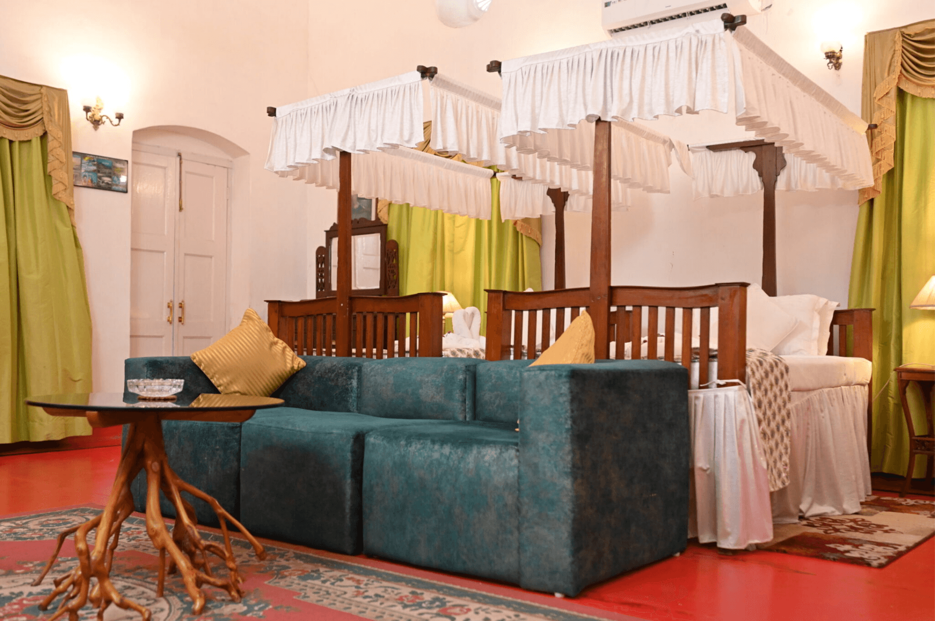 A guest room at Thengal Manor with a carved four-poster bed and seating.