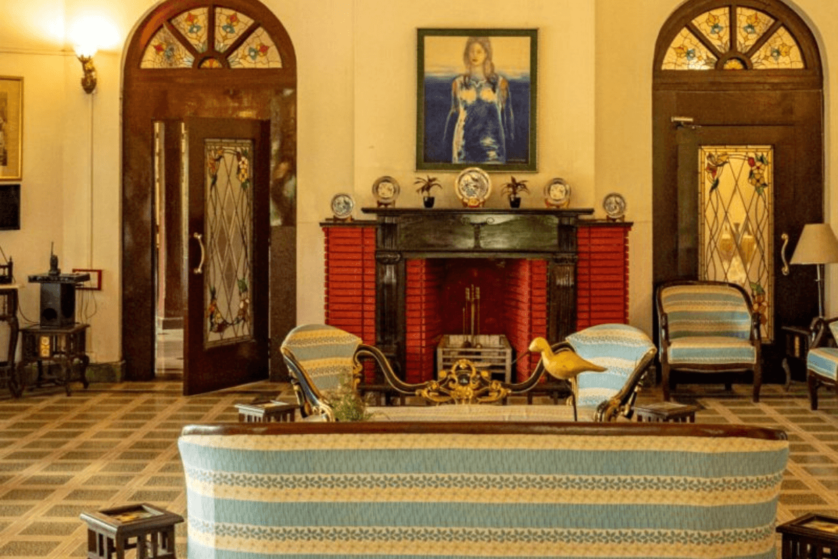 The sitting room at Banyan Grove with a fireplace, arched doors and antique furniture.