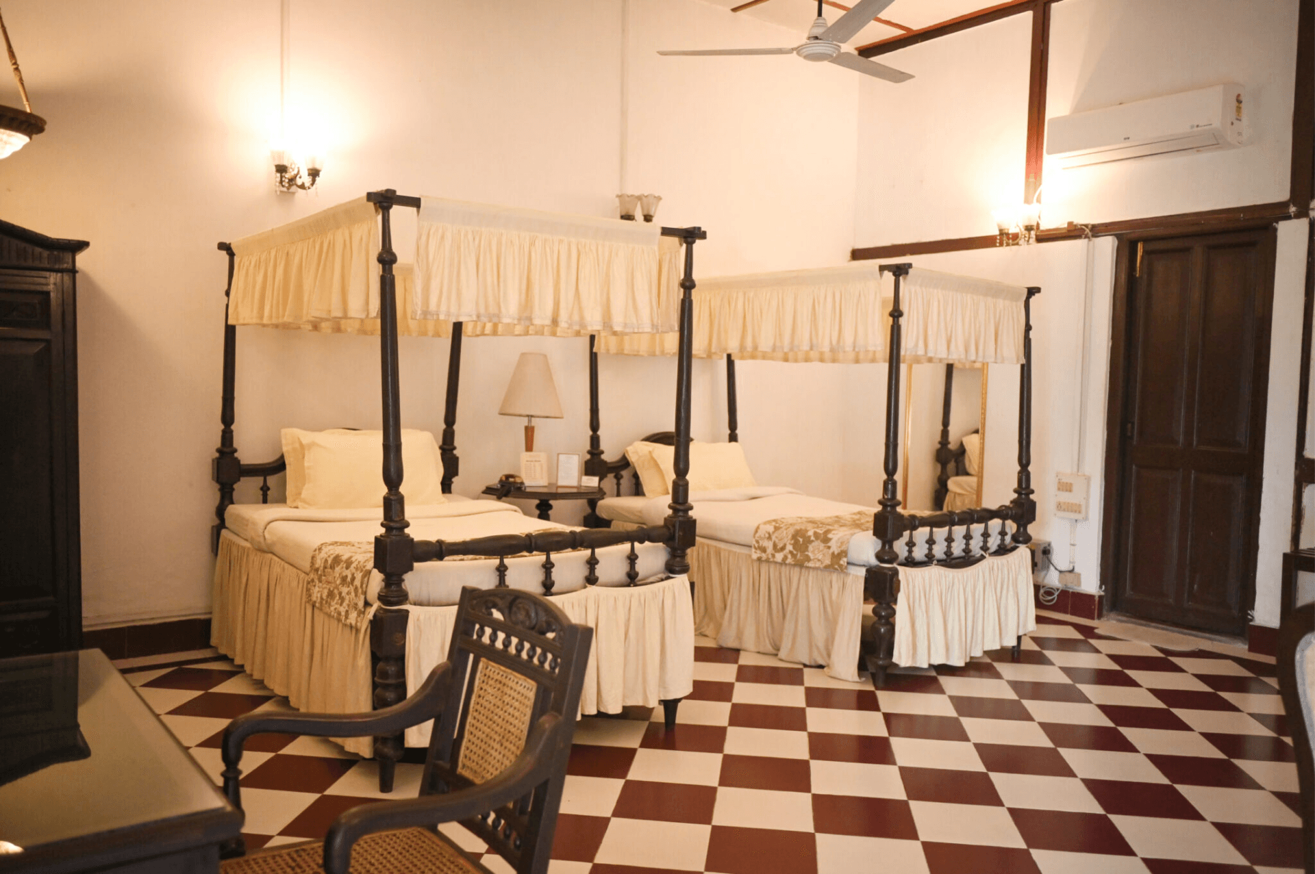 A second guest room at Banyan Grove with twin four-poster beds.