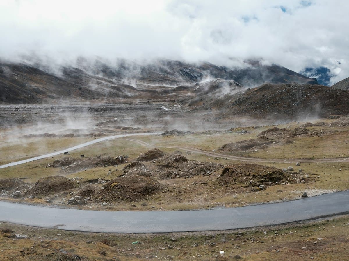 A road winding through bare high-altitude mountain ranges in Sikkim.