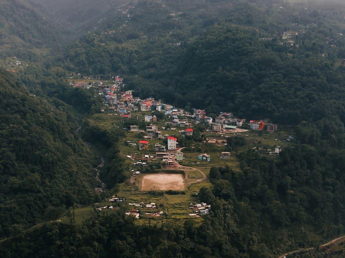 A hillside village scattered through dense forest on a ridge near Pelling, West Sikkim.