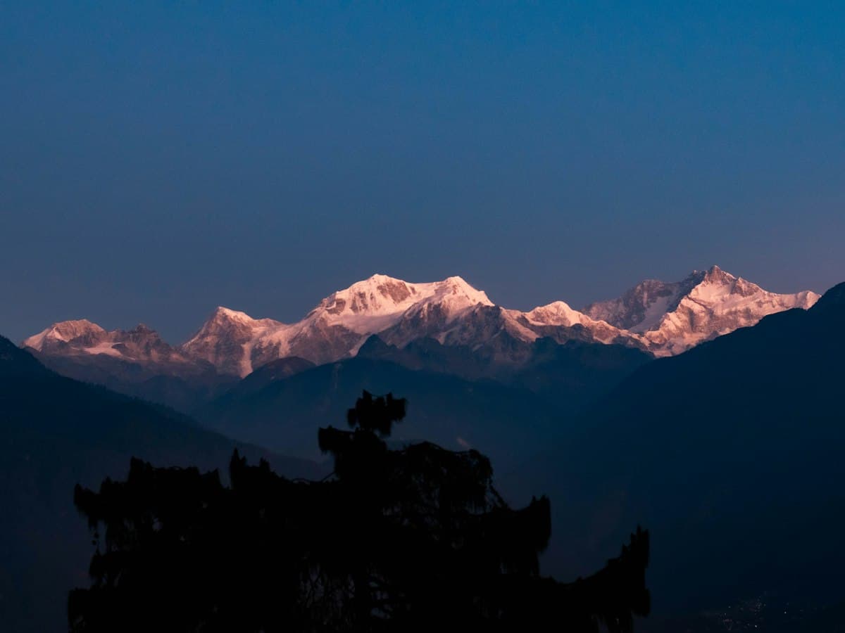 First light strikes the snow of the Kangchenjunga massif seen from Pelling, West Sikkim.