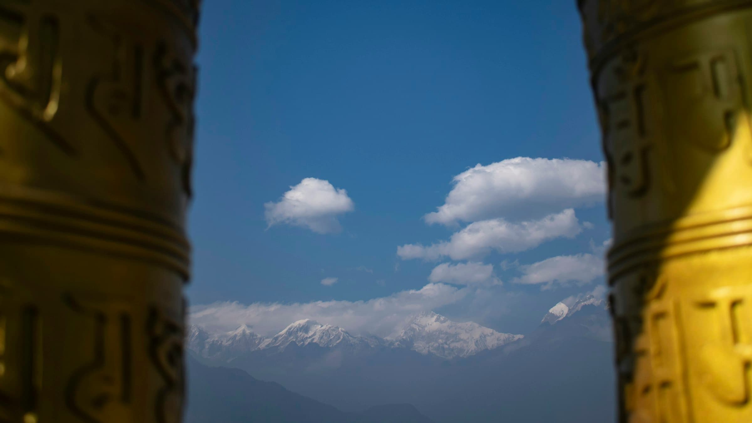 The Himalayan range framed between two gilded pillars at Pemayangtse Monastery, West Sikkim.