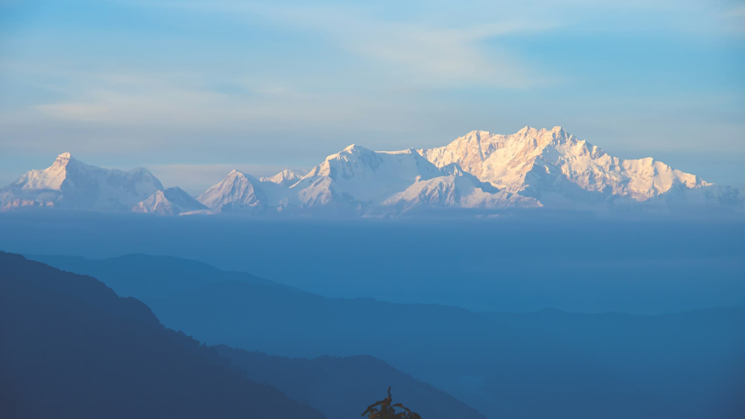 The Kanchenjunga skyline in layered silhouette against a coloured twilight sky over the eastern Himalayan ridges.