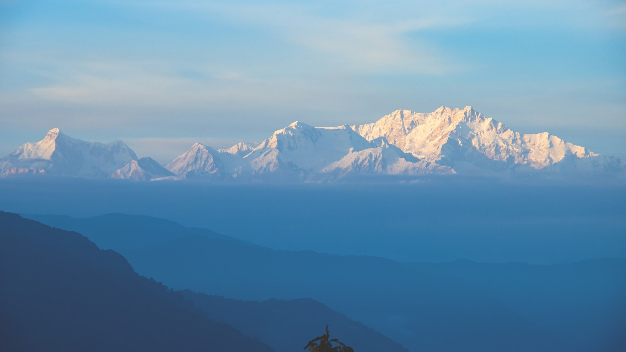 The Kanchenjunga skyline in layered silhouette against a coloured twilight sky over the eastern Himalayan ridges.