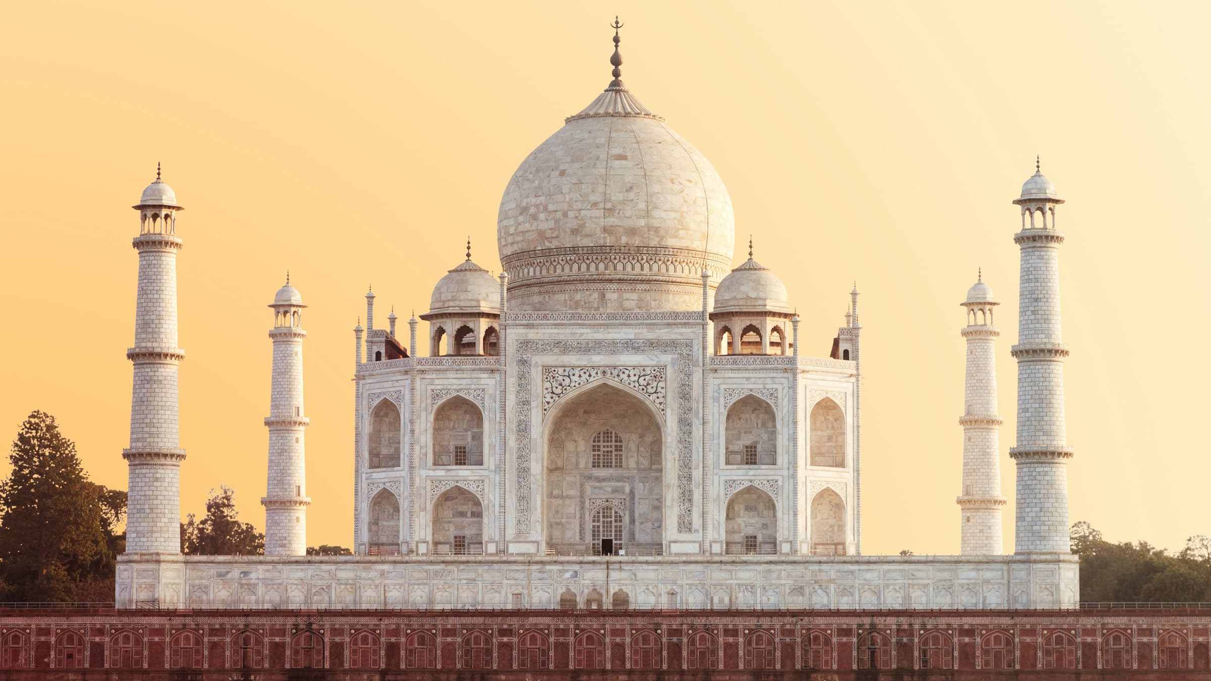 The Taj Mahal glows under a warm golden-hour sky in Agra, India.