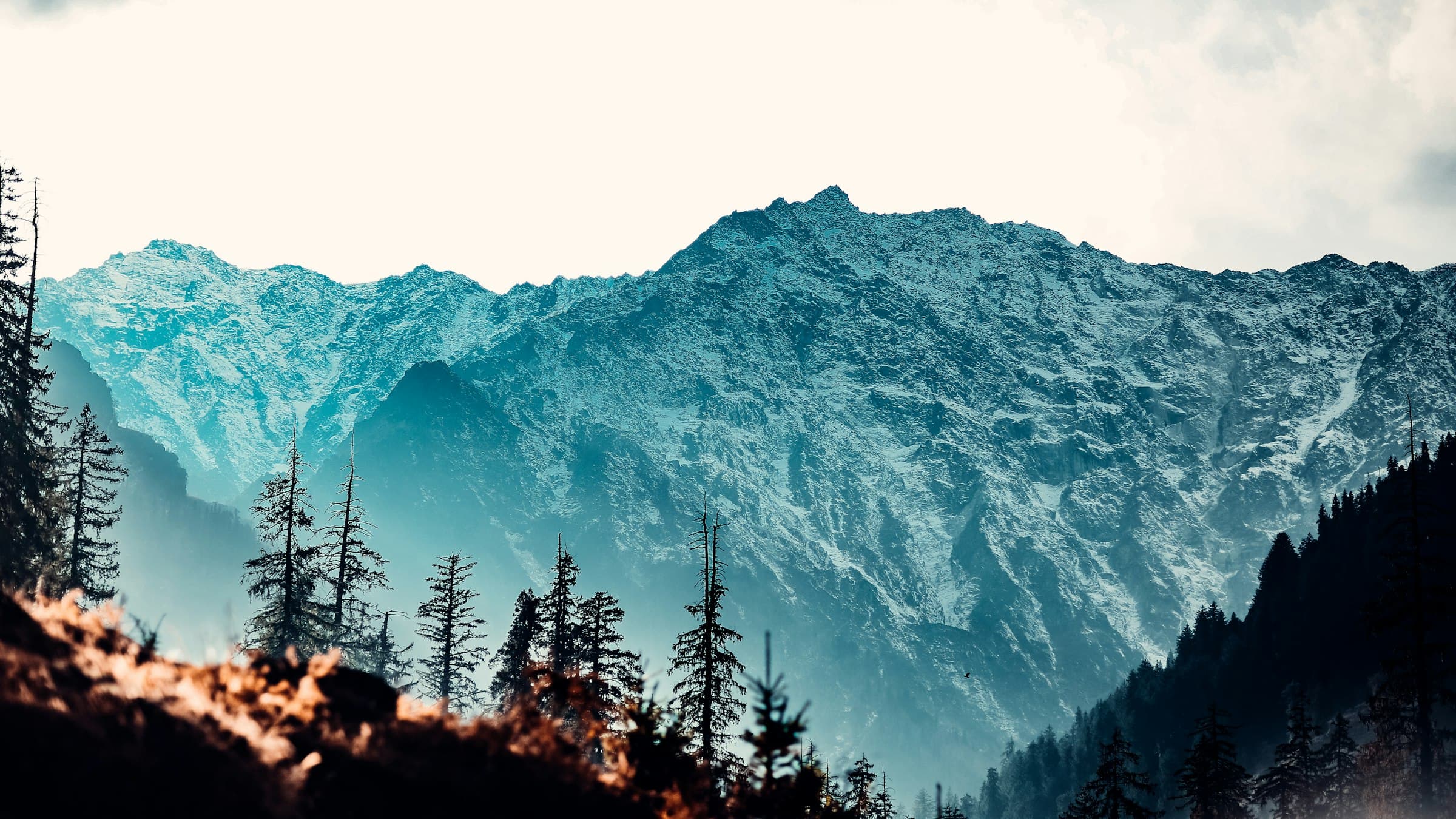 Layered blue Himalayan ridges recede toward a distant snow-covered range near Manali.