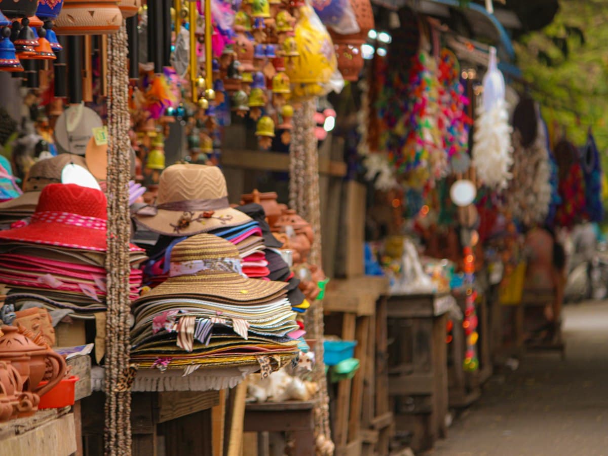 A woman walks a street past a market in Pondicherry's White Town / French Quarter.