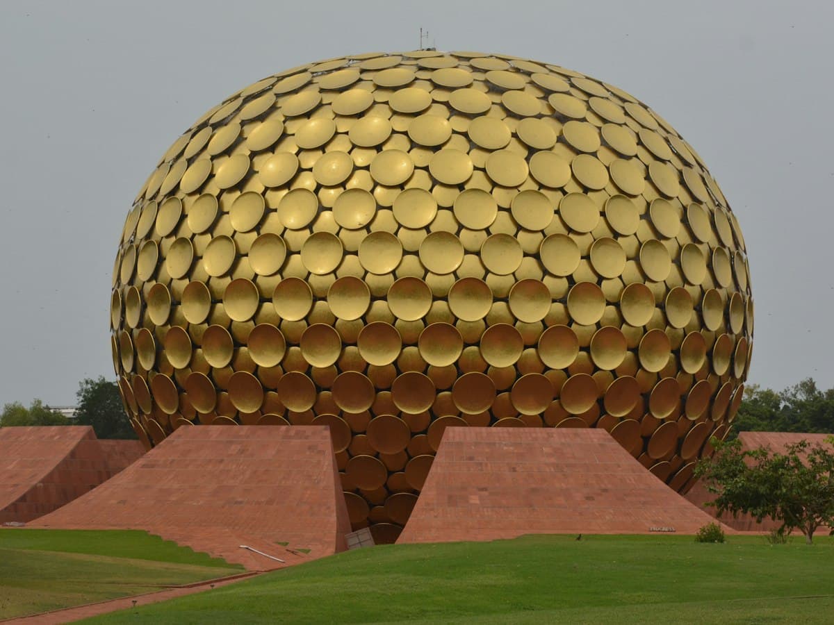 The golden geodesic sphere of the Matrimandir rising from lawns at Auroville, near Pondicherry.