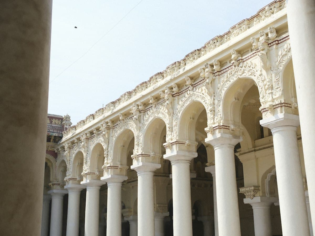 The tall pillared colonnade with arches and carvings at Thirumalai Nayakkar Mahal palace, Madurai.