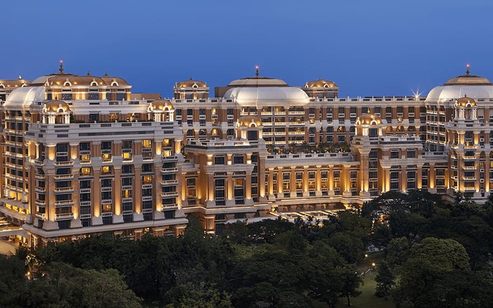 Illuminated Dravidian-style facade of ITC Grand Chola, Chennai, at dusk