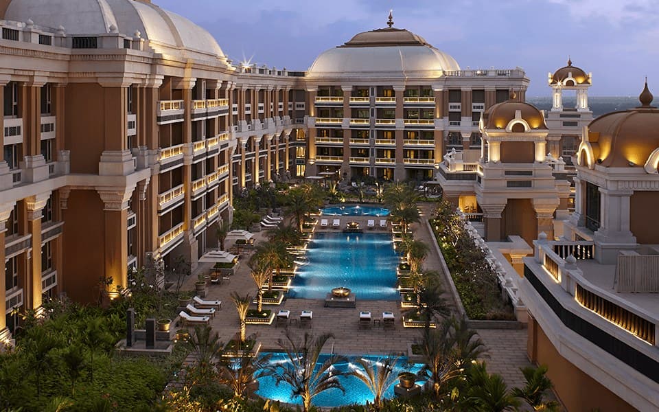 Aerial view of the outdoor pool and domed towers of ITC Grand Chola, Chennai, at dusk