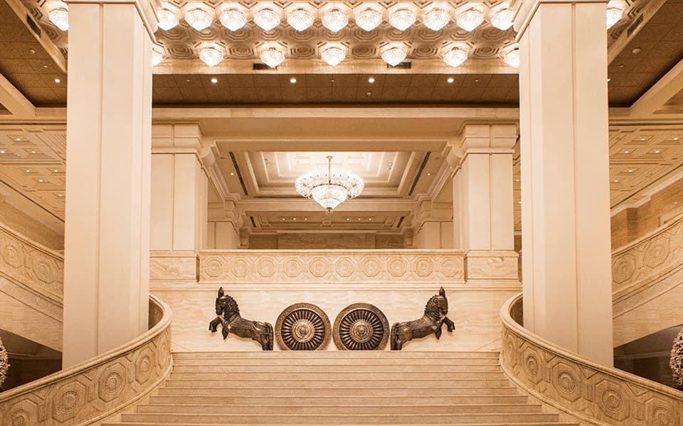 The grand staircase with stone horse sculptures in the lobby of ITC Grand Chola, Chennai