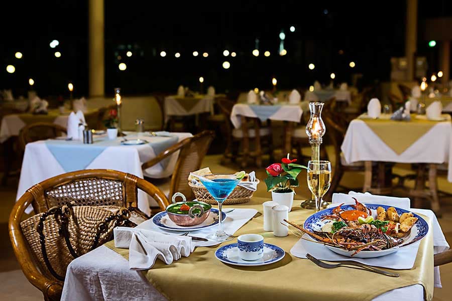 Open-air dining tables set in the evening at Ideal Beach Resort, Mamallapuram