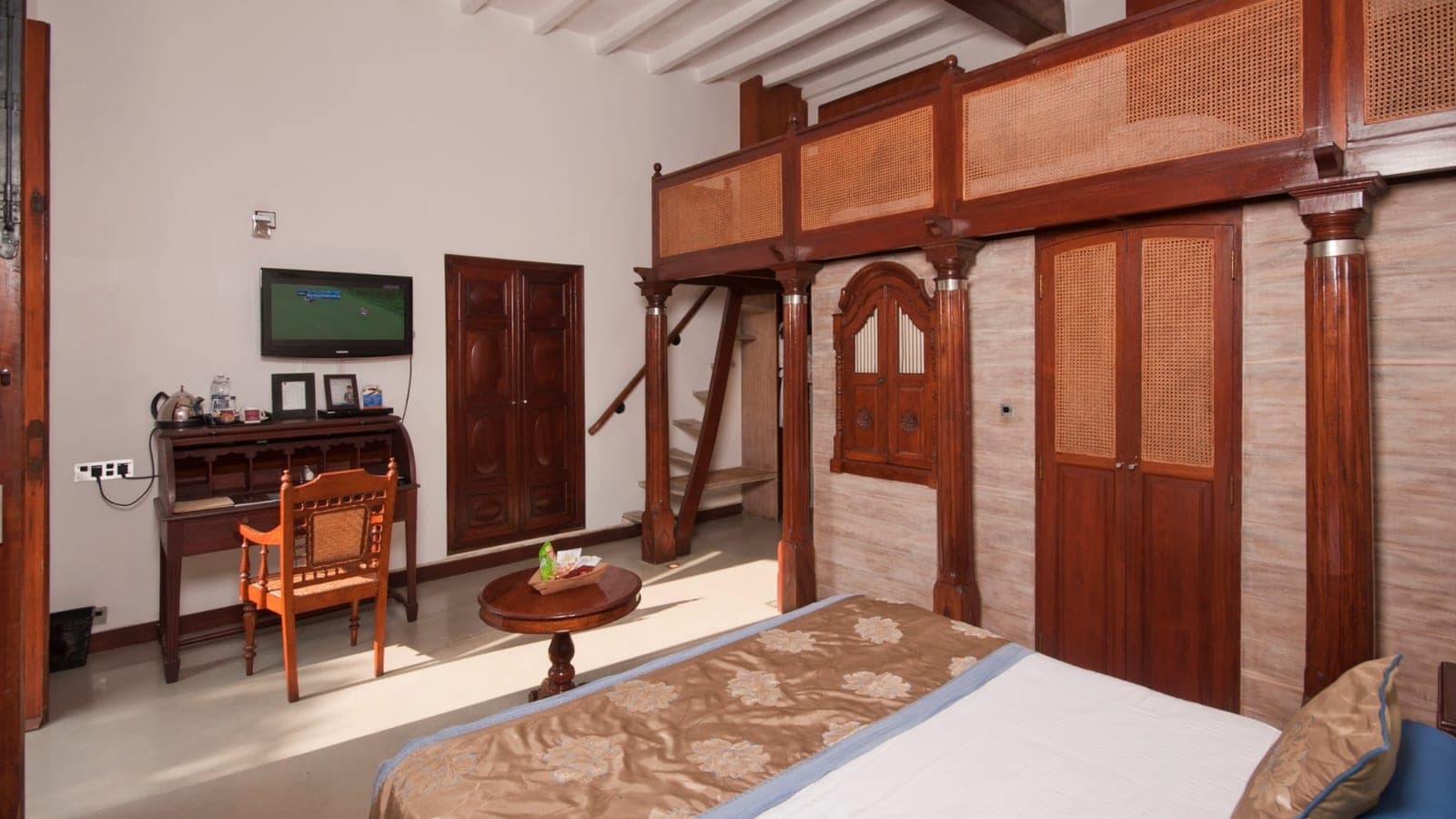 Superior room with wood-panelled walls and a stone floor at Le Dupleix, Pondicherry