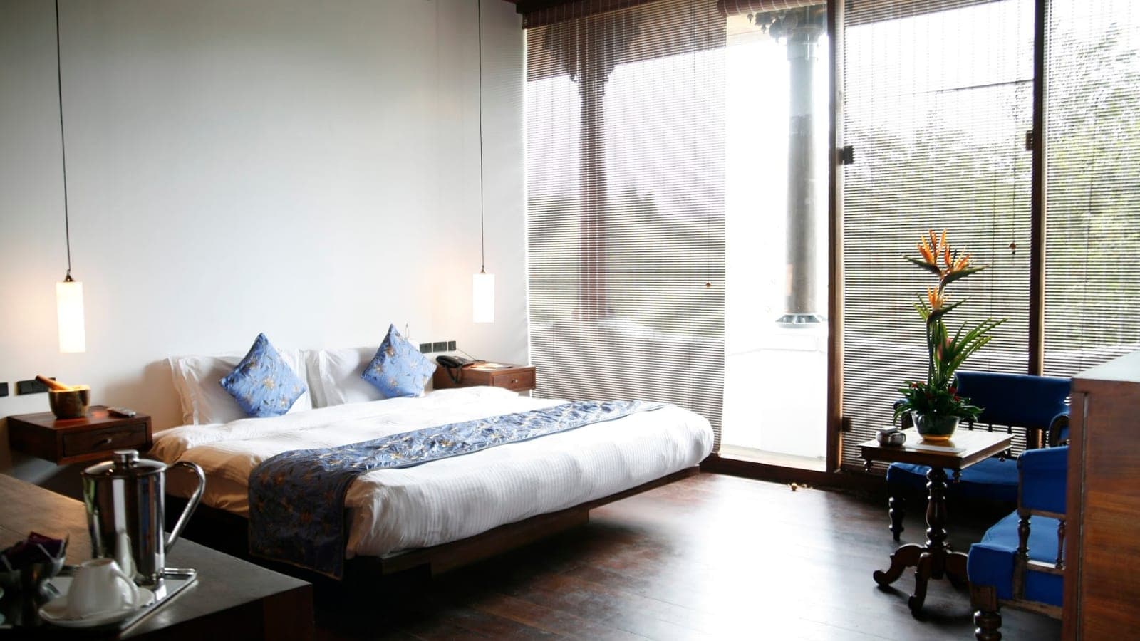 Penthouse room with a bed beside floor-to-ceiling windows at Le Dupleix, Pondicherry