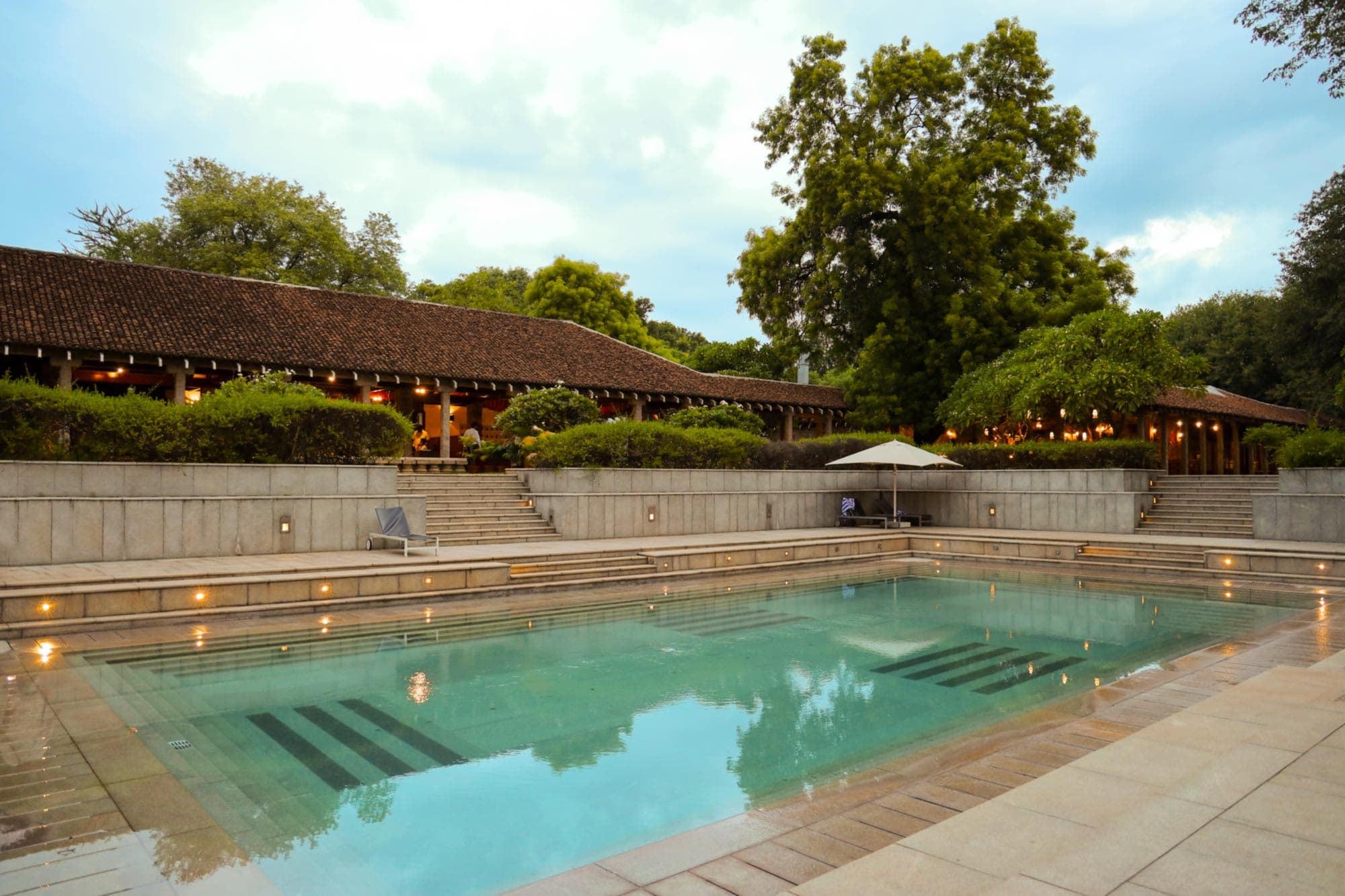 Outdoor swimming pool set among gardens at Heritage Madurai, Madurai