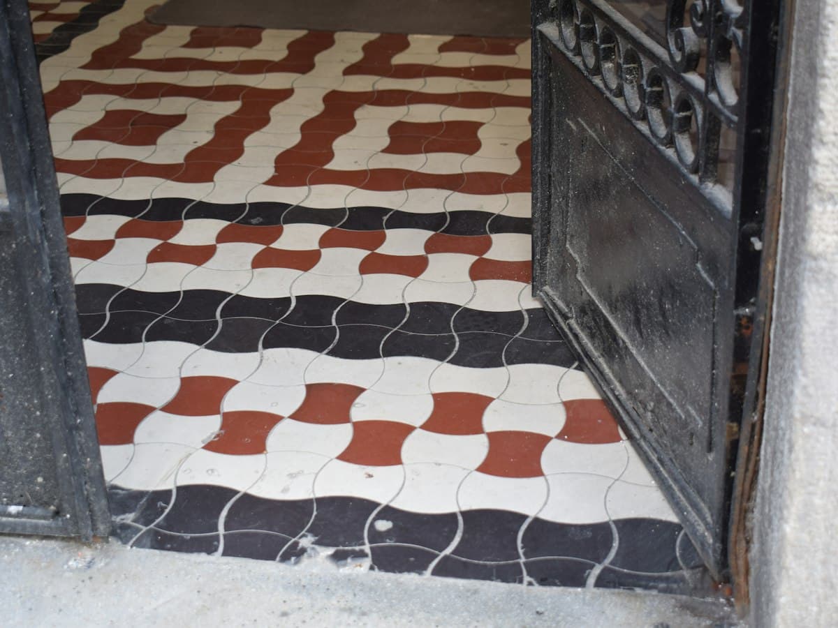 Ornate geometric floor tiles in black, white and red in a traditional South Indian house.