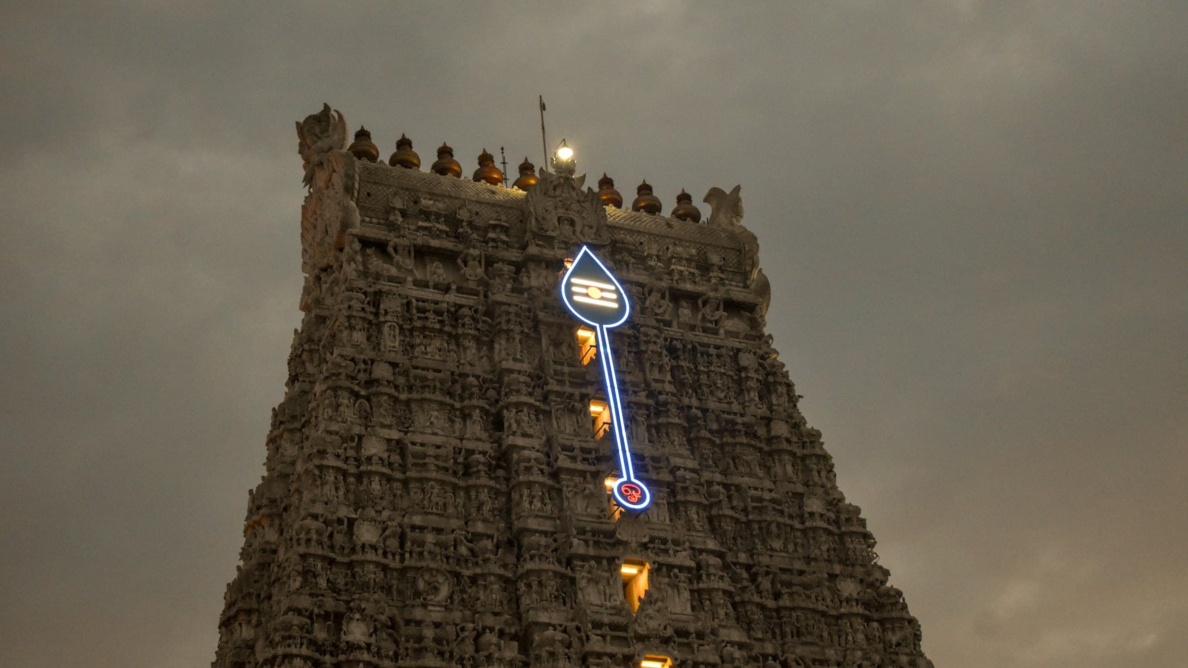 A towering tiered Dravidian gopuram of a South Indian temple rises against the sky at Tiruchendur.