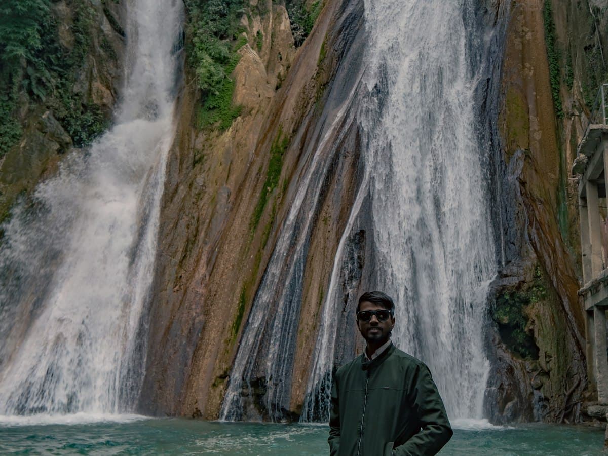 A visitor stands before the multi-stage cascade of Kempty Falls near Mussoorie, Uttarakhand