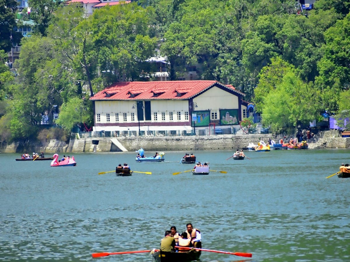 Boats on Naini Lake in Nainital, ringed by forested hills, Uttarakhand