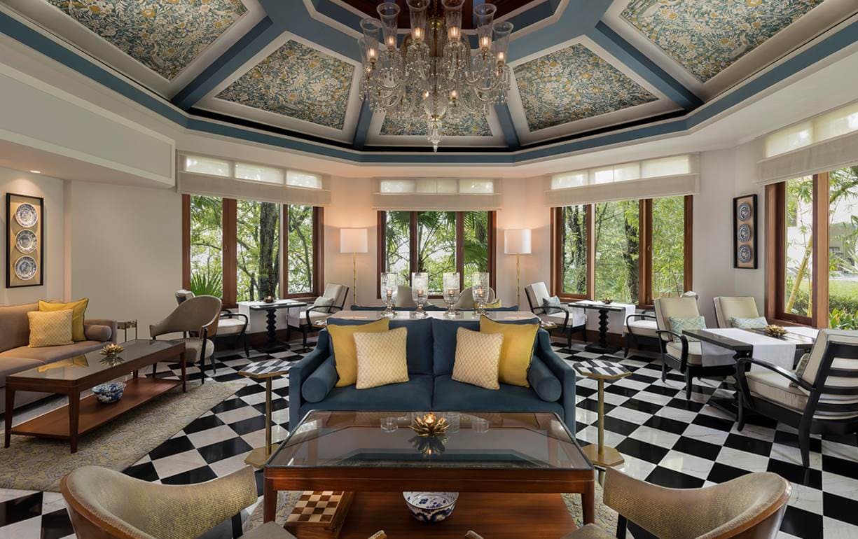 Restaurant pavilion seating area at Ananda in the Himalayas with garden views through arched windows.
