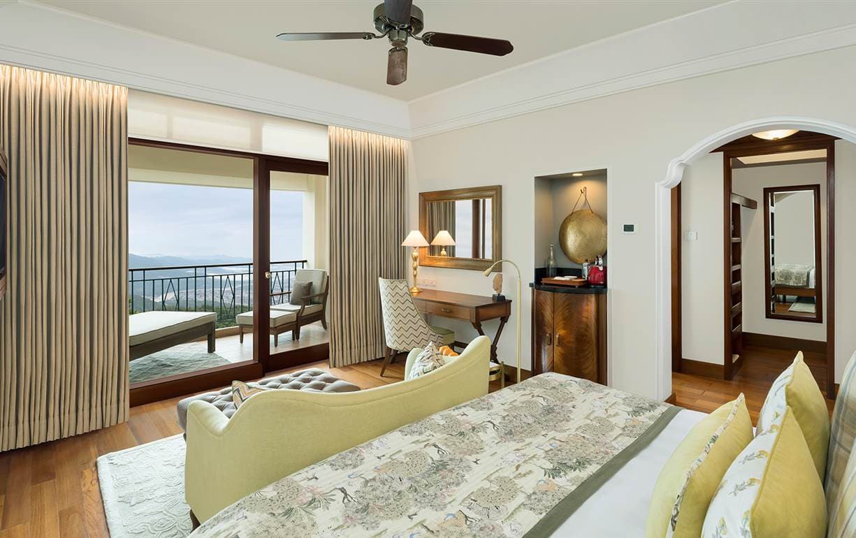 Deluxe Room bedroom with balcony and valley view at Ananda in the Himalayas.