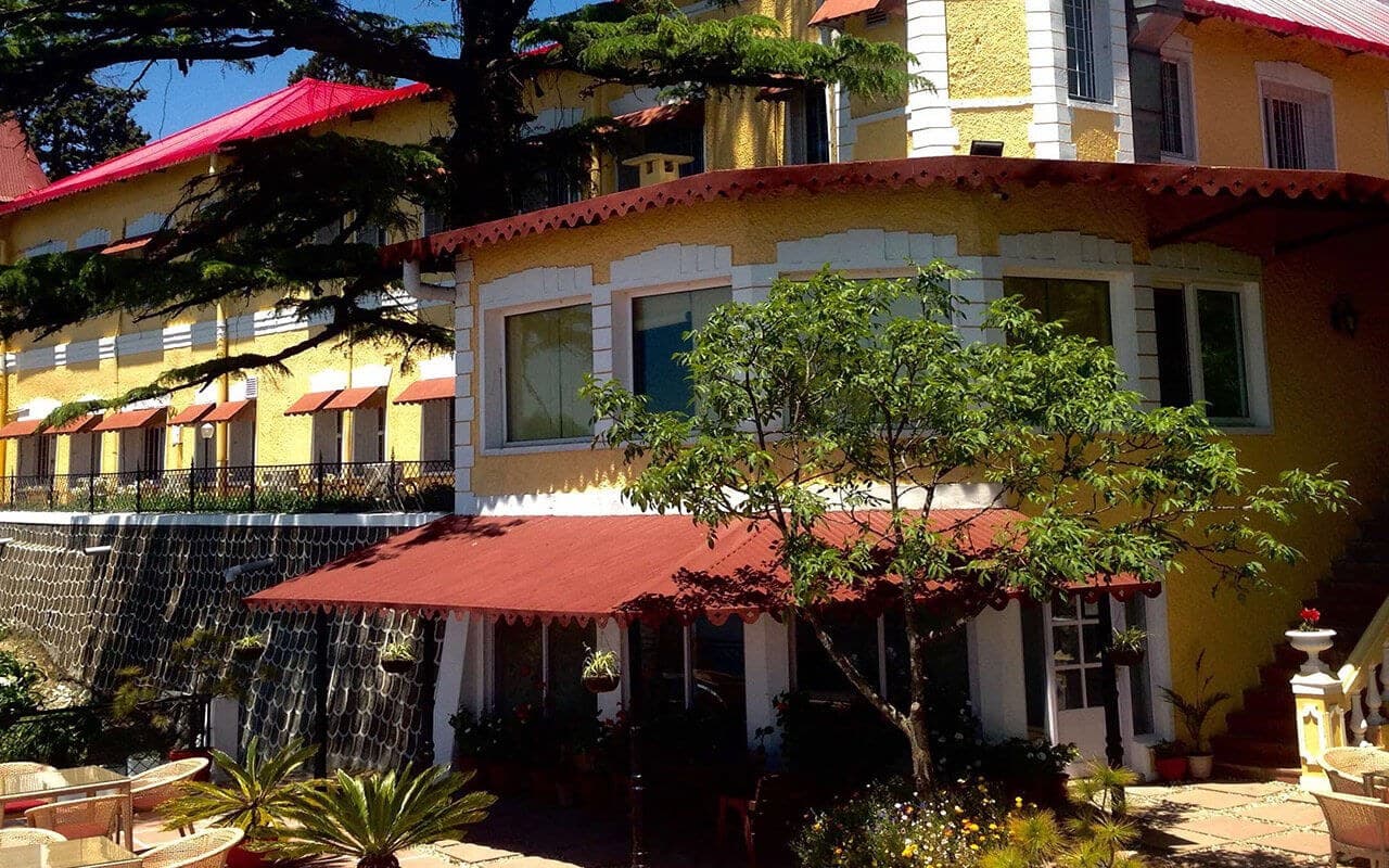 Exterior view of Kasmanda Palace's heritage architecture and grounds, Mussoorie.
