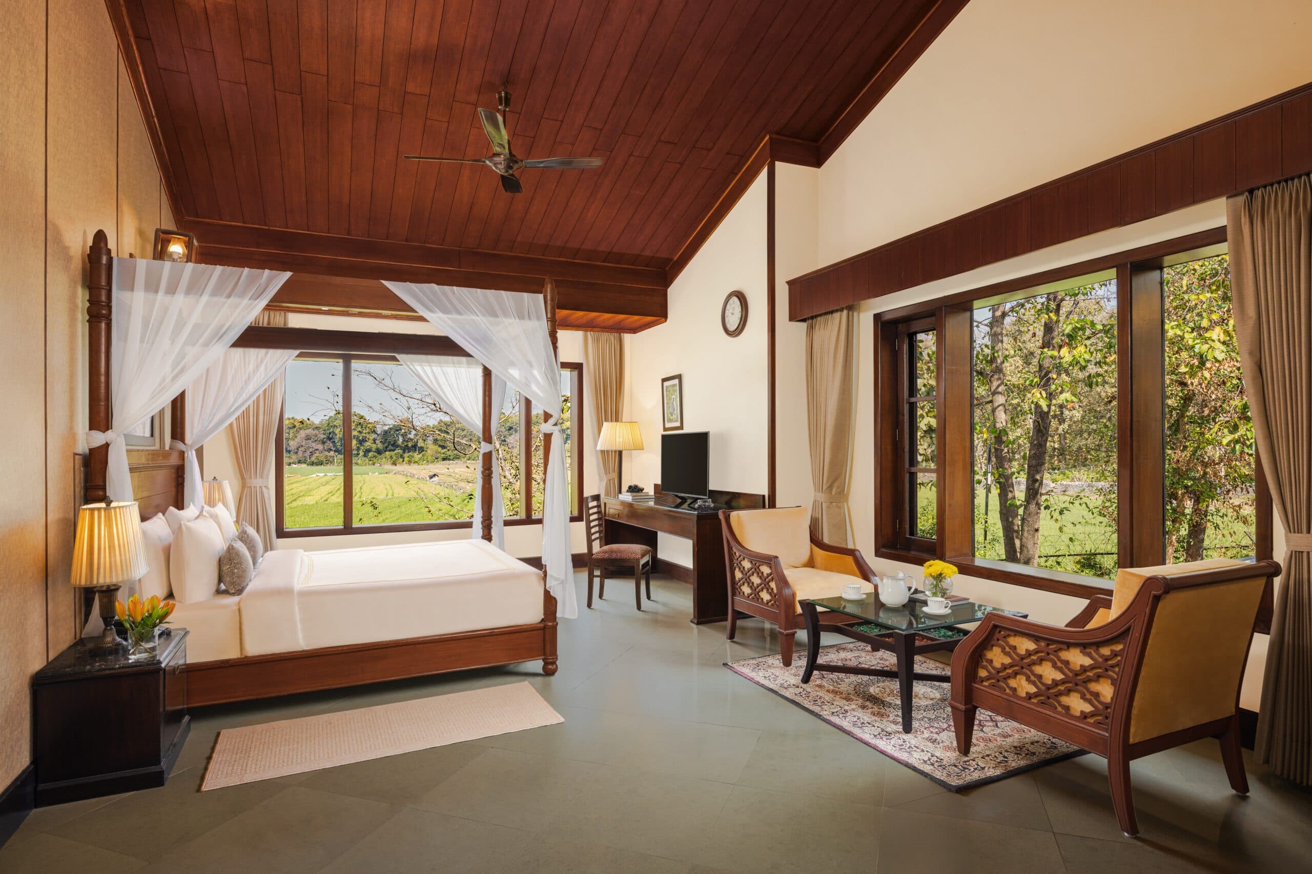 Aahana - The Corbett Wilderness Classic Stays bedroom with a four-poster canopy bed overlooking open fields