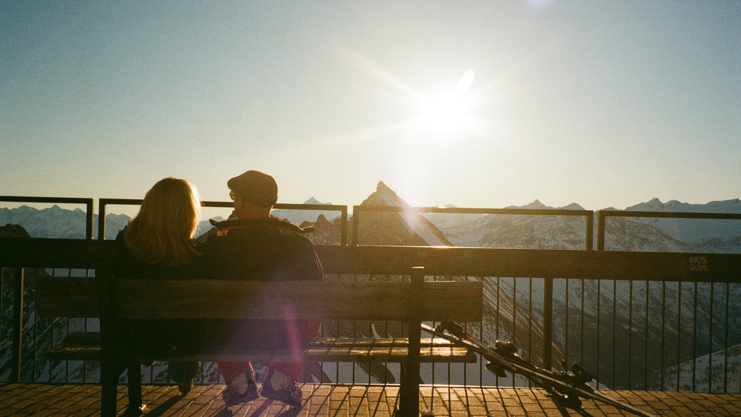 A couple takes in a sweeping mountain sunset view together.