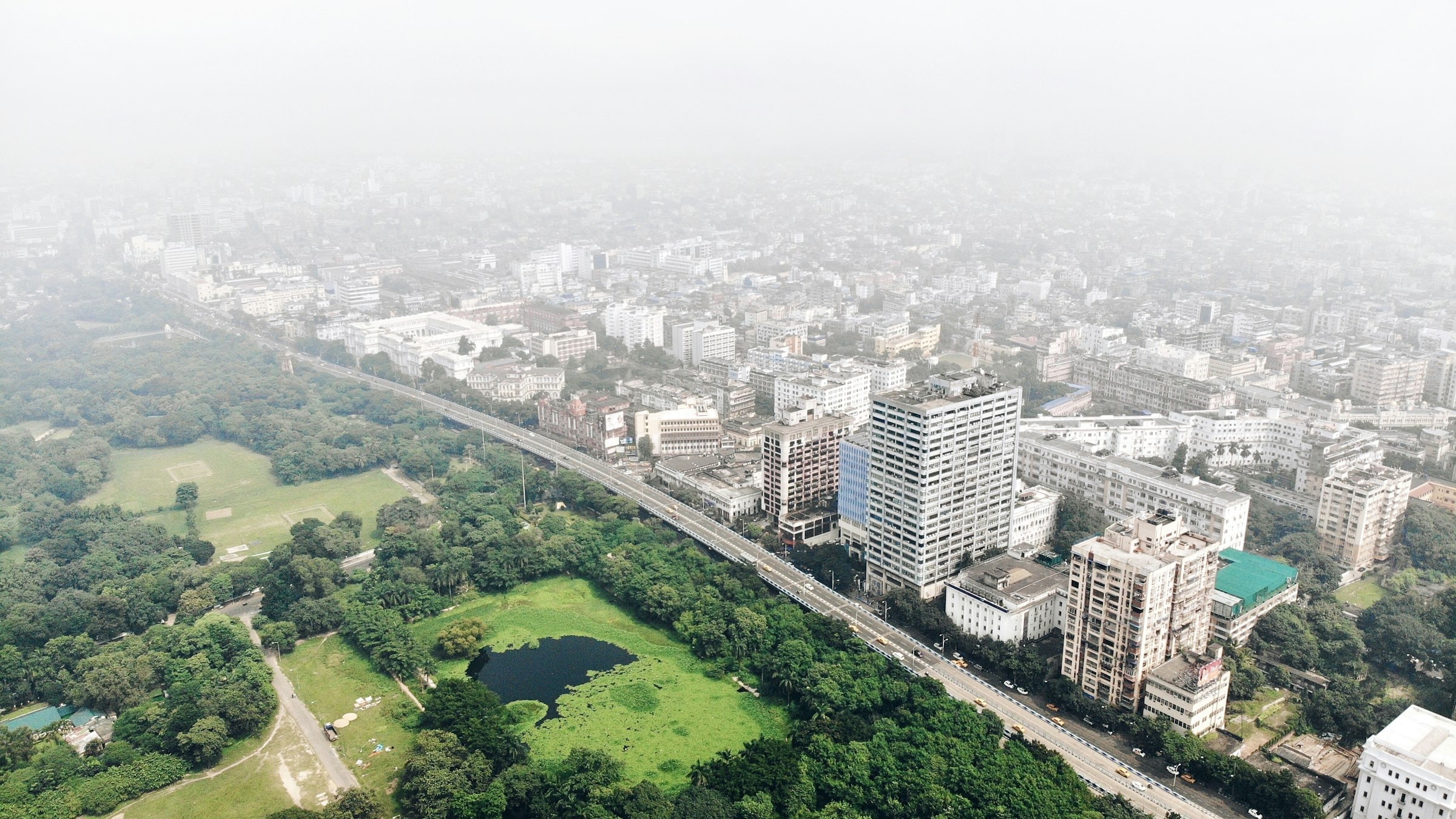 Aerial view of Kolkata's high-rise skyline and green park during daytime
