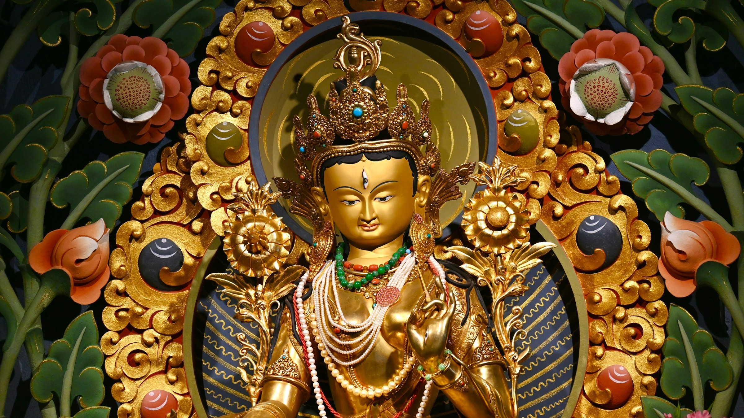 A gilded Buddha statue amid flowers at Gonjang Monastery on the North Sikkim Highway near Gangtok