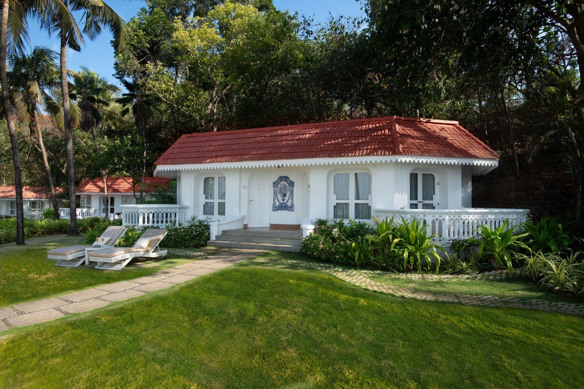 Whitewashed Portuguese-style villa with red-tiled roof and lawn at Taj Fort Aguada Resort & Spa