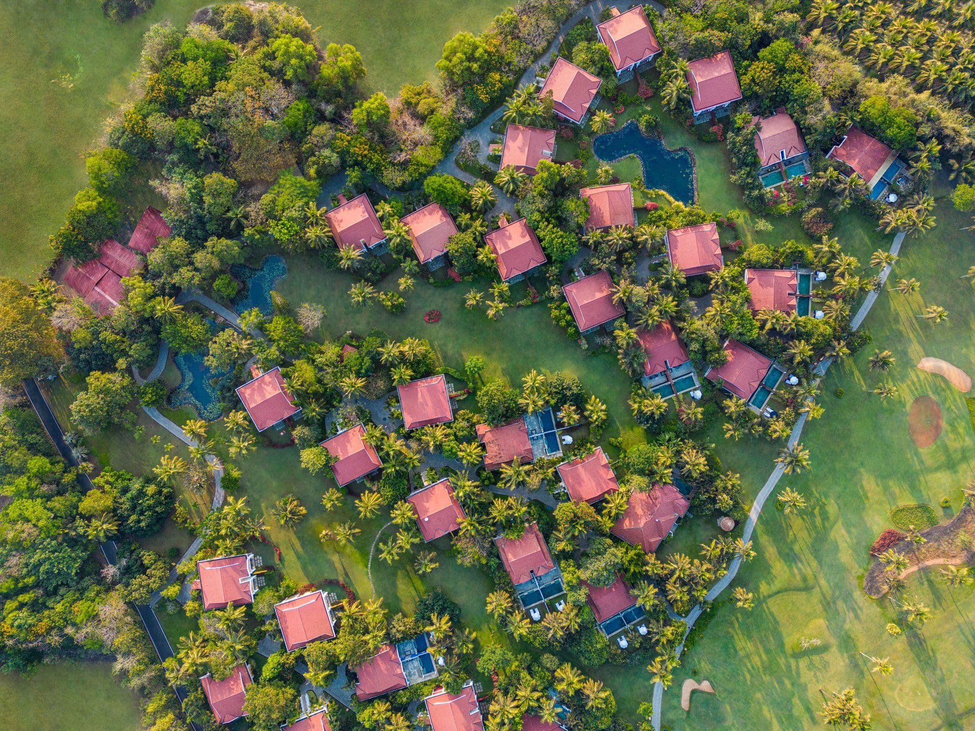 Aerial view of red-roofed villas amid palms and gardens at Taj Exotica Resort & Spa