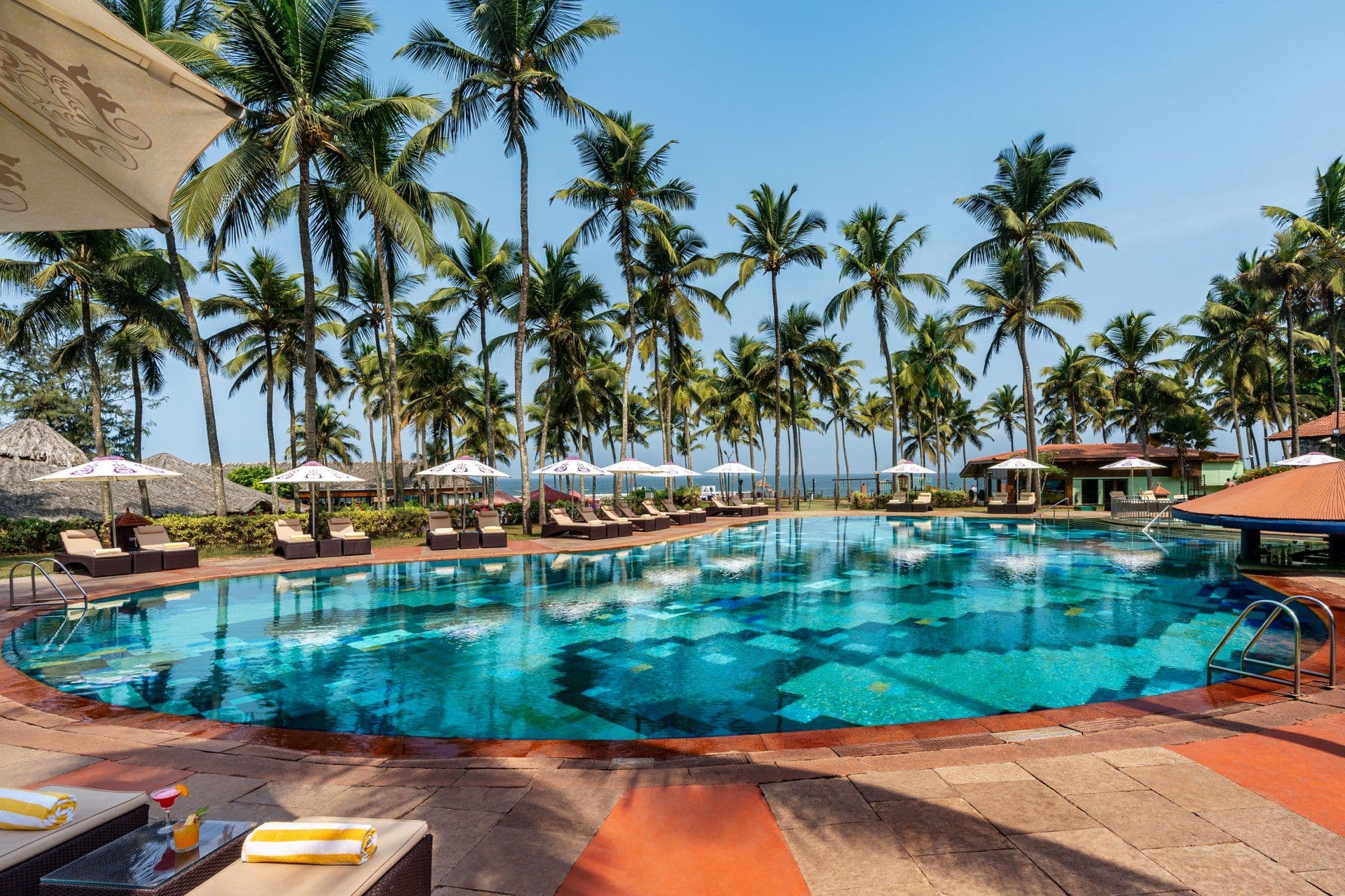 Swimming pool ringed by palm trees at Taj Holiday Village Resort & Spa, Goa