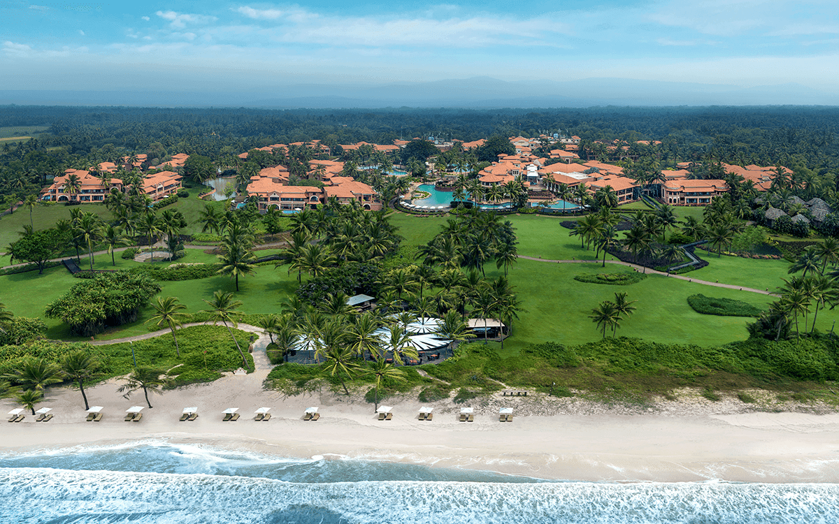 Aerial view of ITC Grand Goa Resort & Spa, its terracotta-roofed villages and Arossim Beach