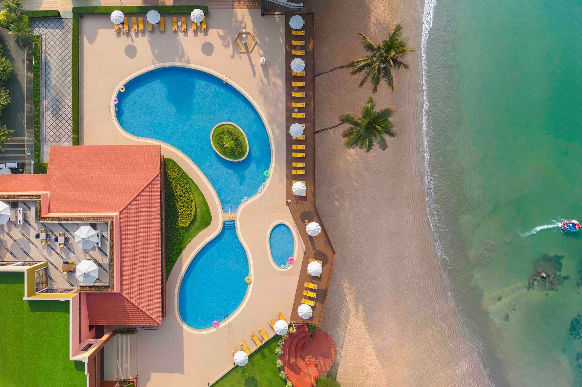 Aerial view of the lagoon-style pool beside Vainguinim Beach at Taj Cidade de Goa Heritage