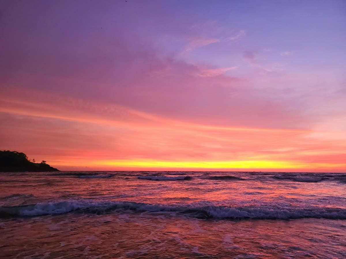 Pink sunset over waves at Cavelossim beach, South Goa