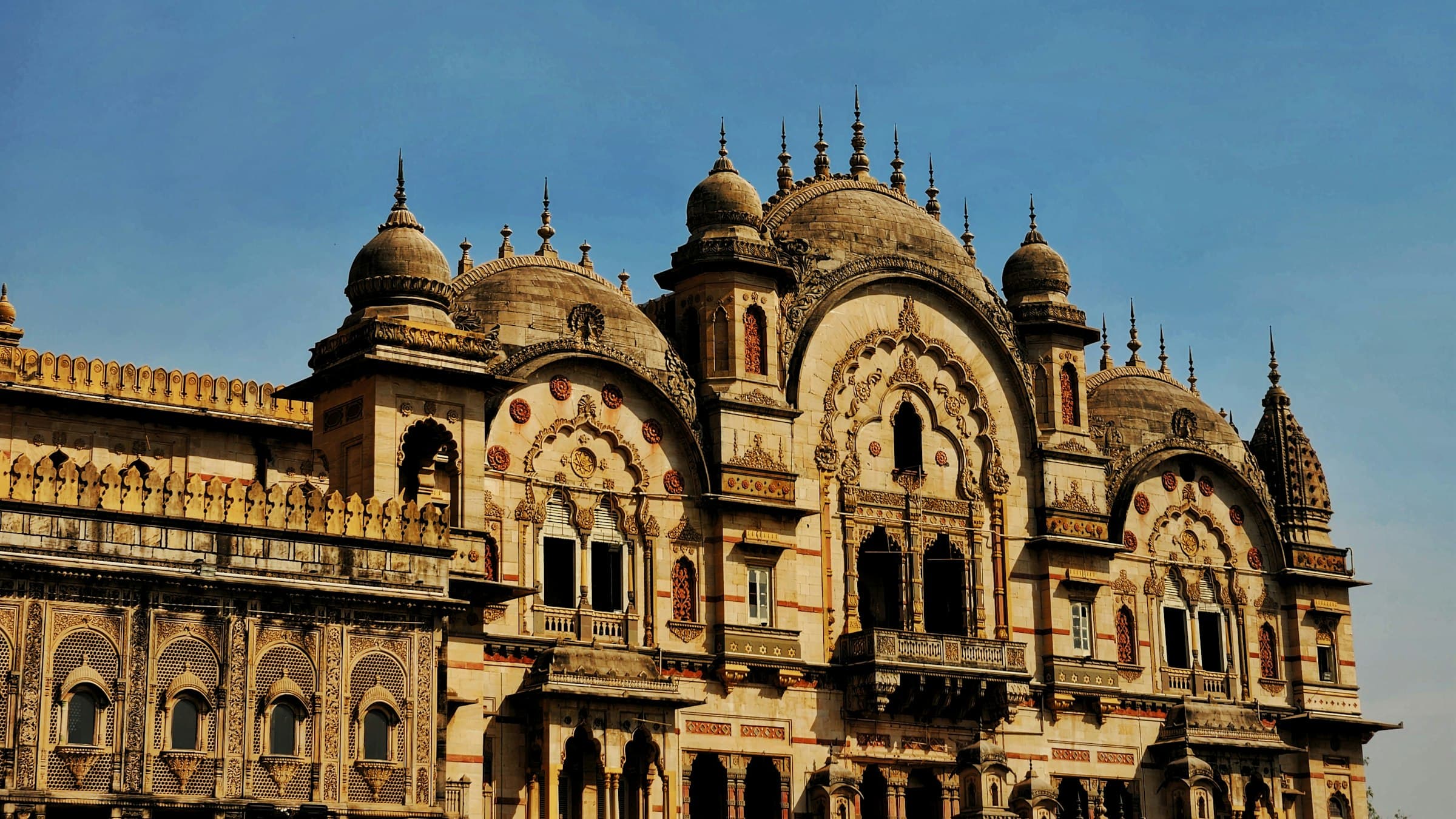 Ornate arched and domed facade of Laxmi Vilas Palace in golden daylight, Vadodara, Gujarat