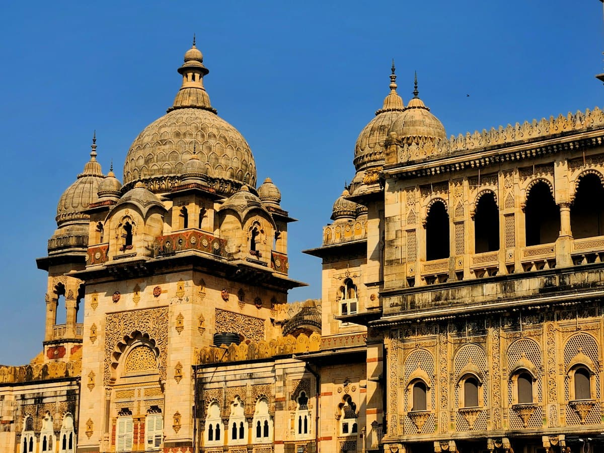 Domed towers and arched facade of Laxmi Vilas Palace, Vadodara, Gujarat, against a blue sky