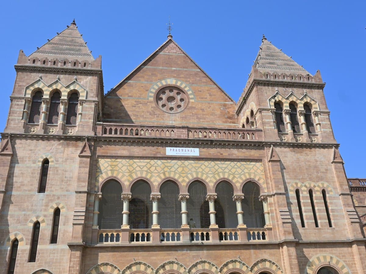 Italianate Gothic facade of Prag Mahal in Bhuj, Gujarat, with twin towers and arcaded loggia.