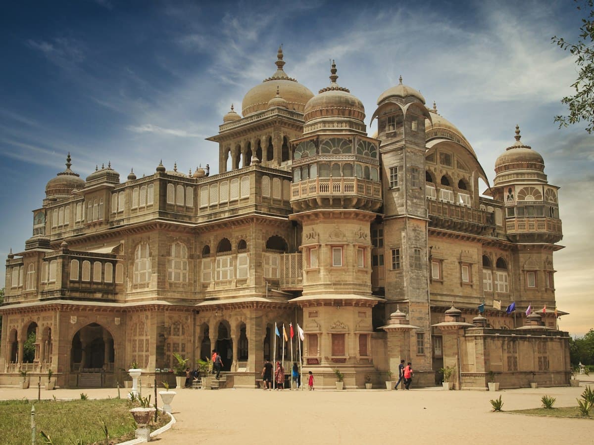 Sandstone facade of Vijay Vilas Palace at Mandvi, Kutch, with domed chhatris and jharokha balconies.