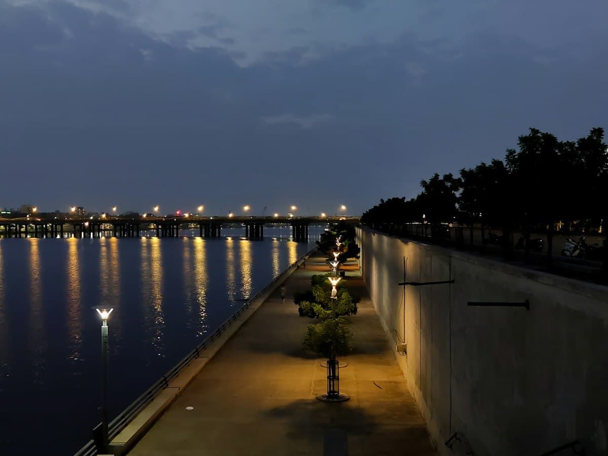 Lit promenade and bridge along the Sabarmati riverfront, Ahmedabad, at dusk